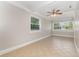 Spacious room with neutral paint, tile floors, large windows, and a ceiling fan providing ample natural light at 3675 Rundo Dr, Orlando, FL 32818