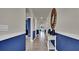 Hallway with archways, tile floor, table, mirror, and blue paneled walls at 3751 Bluethread Way, Poinciana, FL 34759