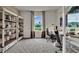 Spacious home office with a bookshelf, two desks, and a large window at 3751 Bluethread Way, Poinciana, FL 34759