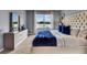 Inviting bedroom features a large window, dresser, and a cozy bed with blue decorative pillows at 3751 Bluethread Way, Poinciana, FL 34759