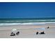 Relaxing beach scene featuring people enjoying the sun, sand, and surf under a clear blue sky at 4153 S Atlantic Ave # 1070, New Smyrna Beach, FL 32169