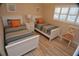 Cozy bedroom featuring two twin beds with striped bedding and orange pillows, next to a white nightstand and sunny windows at 4153 S Atlantic Ave # 1070, New Smyrna Beach, FL 32169