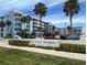 Sea Coast Gardens III complex showcases a blue exterior, tropical landscaping, and ample parking under a sunny sky at 4153 S Atlantic Ave # 1070, New Smyrna Beach, FL 32169