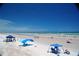 Expansive ocean view with people relaxing under beach tents on a bright, sunny day with clear blue skies at 4153 S Atlantic Ave # 1070, New Smyrna Beach, FL 32169