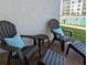 Relaxing patio with comfortable Adirondack chairs and side tables, offering a view of the sparkling community pool at 4153 S Atlantic Ave # 1070, New Smyrna Beach, FL 32169