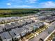 An aerial view showcasing modern multi-colored townhomes in a community with lake and wooded areas at 4164 Paragraph Dr, Kissimmee, FL 34746
