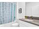 Well-lit bathroom featuring a shower-tub combo with stylish shower curtain and a modern vanity with a gray countertop at 4164 Paragraph Dr, Kissimmee, FL 34746