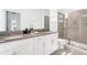 Bright bathroom featuring double sinks, modern fixtures, and a glass-enclosed shower at 4164 Paragraph Dr, Kissimmee, FL 34746