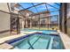 Backyard featuring screened-in pool with attached hot tub and landscaped yard at 4164 Paragraph Dr, Kissimmee, FL 34746