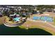 Community aerial view highlighting the pool, clubhouse, and sports courts near the lake at 4175 Sw 46Th Ct, Ocala, FL 34474