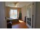 A bedroom with a ceiling fan, wood floors, and view to an exterior window at 4175 Sw 46Th Ct, Ocala, FL 34474