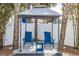 Cozy backyard nook with seating under a gazebo with lush trees for privacy at 435 Jessamine Ave, New Smyrna Beach, FL 32169
