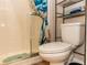 Bathroom featuring a toilet, shower with a blue and white curtain, and shelving for organized storage at 435 Jessamine Ave, New Smyrna Beach, FL 32169