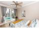 Bedroom with sliding glass door to outdoor patio, ceiling fan, and vibrant, beachy decor at 435 Jessamine Ave, New Smyrna Beach, FL 32169