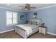 Bedroom with blue walls, ceiling fan, striped bedding, and a beach themed decor for a cozy ambiance at 435 Jessamine Ave, New Smyrna Beach, FL 32169