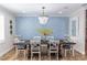 Elegant dining room with wood table, chairs, decorative chandelier and wainscoting on accent wall at 435 Jessamine Ave, New Smyrna Beach, FL 32169