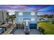 Charming elevated beach house with blue siding, white trim, and well-manicured lawn at dusk at 435 Jessamine Ave, New Smyrna Beach, FL 32169