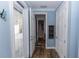 Hallway with wood floors, white trim, leading to an outdoor area and a bathroom beyond at 435 Jessamine Ave, New Smyrna Beach, FL 32169