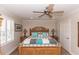 Cozy main bedroom with a wooden bed frame, ceiling fan, and shuttered windows at 435 Jessamine Ave, New Smyrna Beach, FL 32169