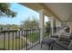 Outdoor covered balcony with black railings, white pillars, and patio furniture overlooking the street at 450 Lakewood Dr, Winter Park, FL 32789