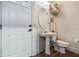 Cozy bathroom with pedestal sink, decorative mirror, and tiled flooring at 450 Lakewood Dr, Winter Park, FL 32789