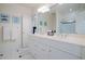 Bathroom with double sinks, white cabinets, and a tiled shower in neutral colors at 450 Lakewood Dr, Winter Park, FL 32789