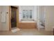 A bathroom with a shower, a large soaking tub, and plantation shutters at 450 Lakewood Dr, Winter Park, FL 32789