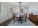 Dining room featuring a decorative chandelier, shuttered windows, wood flooring, and a decorative area rug at 450 Lakewood Dr, Winter Park, FL 32789