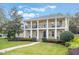 Beautiful two-story home featuring a manicured lawn, lush landscaping, and a welcoming walkway to a covered front porch at 450 Lakewood Dr, Winter Park, FL 32789