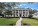 Stunning two-story home with a grand entrance, featuring a beautifully landscaped front yard and second story balcony at 450 Lakewood Dr, Winter Park, FL 32789