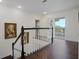 Hallway with dark wood flooring, white trim, and a door leading to an outdoor balcony at 450 Lakewood Dr, Winter Park, FL 32789