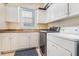 Well-lit laundry room with modern washer and dryer, ample cabinetry, and a sink at 450 Lakewood Dr, Winter Park, FL 32789