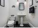 Stylish powder room features a pedestal sink, black and white tile floor, and a modern design at 450 Lakewood Dr, Winter Park, FL 32789