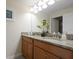 Elegant bathroom featuring a double granite sink and a large mirror at 4879 Clock Tower Dr, Kissimmee, FL 34746