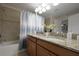 Well-lit bathroom featuring a double granite sink and a bathtub with shower at 4879 Clock Tower Dr, Kissimmee, FL 34746