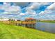 Scenic view of community pond featuring a gazebo, a beautiful lawn, and neighborhood homes in the background at 4879 Clock Tower Dr, Kissimmee, FL 34746
