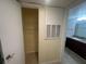 Hallway leading to a closet and bathroom, with a large A/C access panel at 5120 Conroy Rd # 513, Orlando, FL 32811