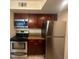 Modern kitchen showcasing stainless steel appliances, granite counters, and dark wood cabinetry at 5120 Conroy Rd # 513, Orlando, FL 32811