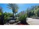 Landscaped walkway lined with lush plants, mature palms, and red flowers at 5120 Conroy Rd # 513, Orlando, FL 32811