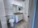 Bathroom featuring toilet, tile floors, granite vanity and updated lighting at 5128 Conroy Rd # 725, Orlando, FL 32811