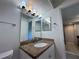 Bathroom featuring sink, granite vanity, updated lighting and tile floor at 5128 Conroy Rd # 725, Orlando, FL 32811