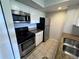 Kitchen featuring stainless steel appliances, granite countertops and white cabinetry at 5128 Conroy Rd # 725, Orlando, FL 32811
