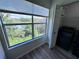 Bright laundry room with large window, dark washer, and wood-look flooring at 5128 Conroy Rd # 725, Orlando, FL 32811