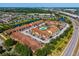 Aerial view of a well-maintained condo complex with a pool, surrounded by lush landscapes, waterways, and nearby shopping at 5201 Vineland Rd # 112, Orlando, FL 32811