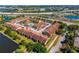 Aerial shot showcases the condo community with a pool, surrounded by lush greenery, waterways, and convenient highway access at 5201 Vineland Rd # 112, Orlando, FL 32811