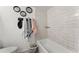 Bright bathroom featuring a tub with tile surround, modern fixtures, and stylish wall decor at 5201 Vineland Rd # 112, Orlando, FL 32811