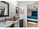 Bathroom featuring double sinks, mirror, and access to the bedroom at 5201 Vineland Rd # 112, Orlando, FL 32811