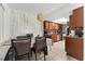 Open floor plan from dining area to kitchen featuring oak cabinetry and tile backsplash at 5201 Vineland Rd # 112, Orlando, FL 32811