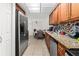 Spacious kitchen with stainless steel appliances, granite countertops, and wooden cabinets at 5201 Vineland Rd # 112, Orlando, FL 32811