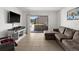 Living room featuring a sectional sofa and a sliding glass door to a patio area at 5201 Vineland Rd # 112, Orlando, FL 32811